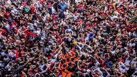 Lula no centro é carregado por uma multidão que ocupa toda a foto