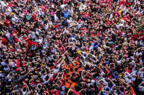 Lula no centro é carregado por uma multidão que ocupa toda a foto