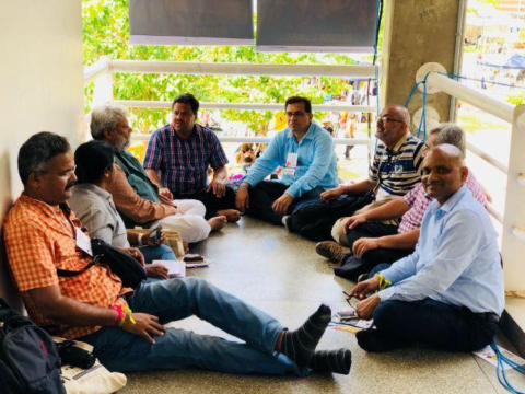indian male delegates to the WSF sitting on the floor
